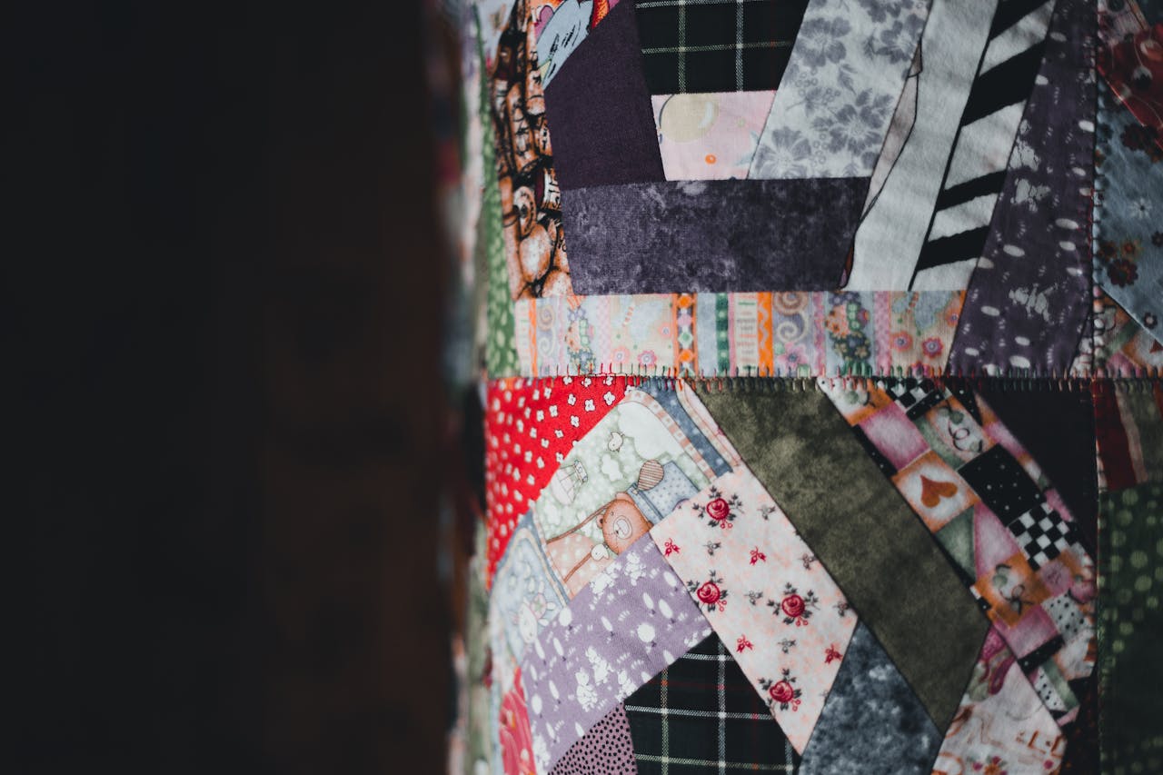 Closeup view of a colorful patchwork quilt featuring various fabrics and patterns.